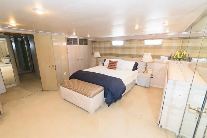 Slide: The Image of Luxurious bedroom on 1984 Broward 100 yacht with elegant decor and ample lighting. - 47