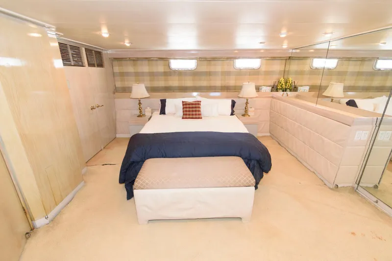 Slide: The Image of Luxurious bedroom interior on a 1984 Broward 100 yacht, featuring elegant decor and comfortable bedding. - 48