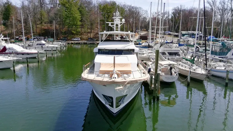Slide: The Image of Luxury yacht Broward 100, 1984 model, docked at a marina surrounded by sailboats. - 6