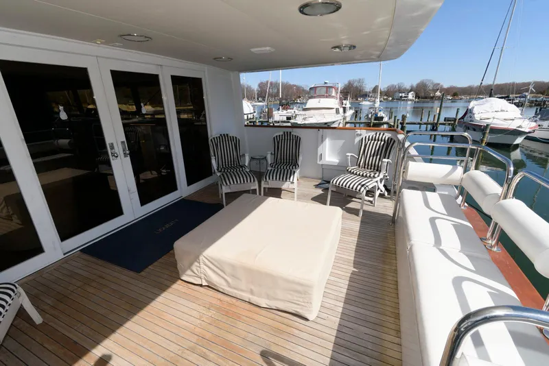 Slide: The Image of Luxury yacht deck with striped chairs, Broward 100, 1984 model, docked at marina. - 9