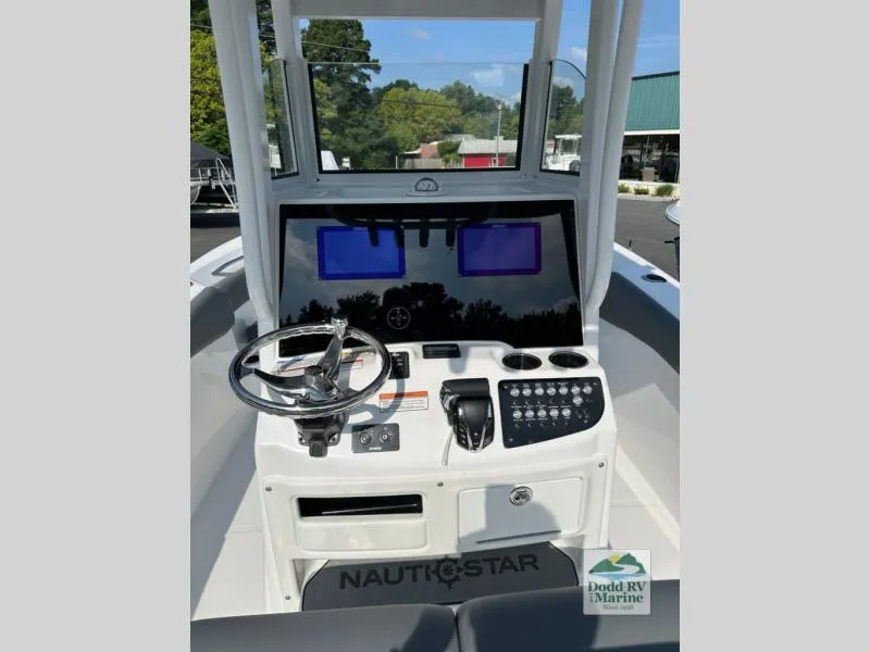 Slide: The Image of 2025 NauticStar 242 Offshore boat dashboard with steering wheel and control panel. - 13