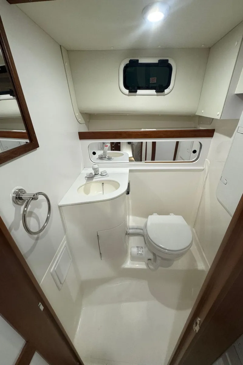 Slide: The Image of 2025 NorthCoast 315 HT boat bathroom with sink, toilet, and window. - 14
