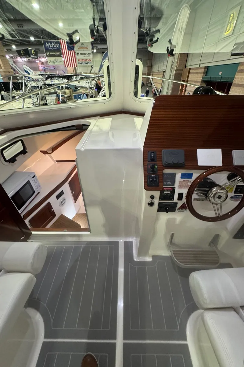 Slide: The Image of Interior view of 2025 NorthCoast 315 HT boat, featuring helm and cabin area. - 17