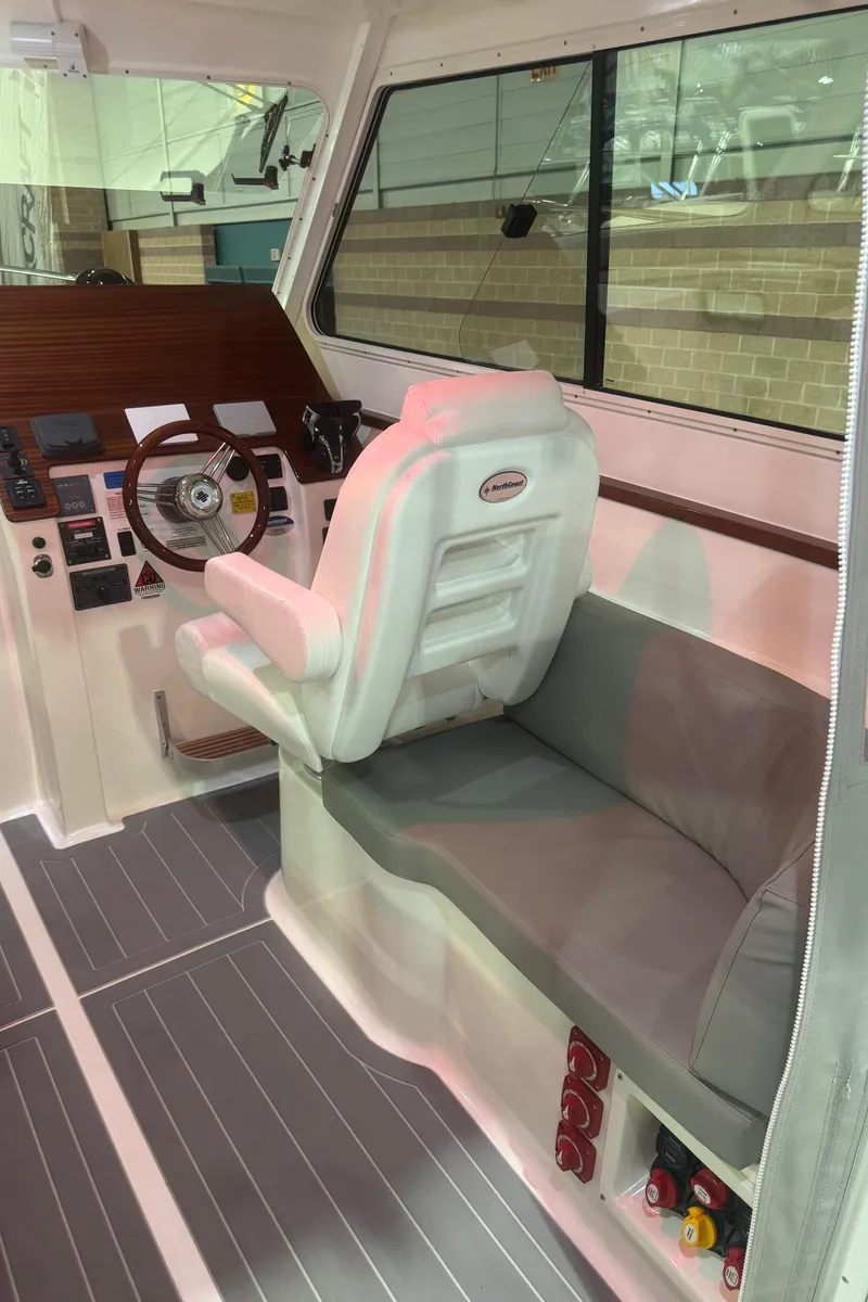 Slide: The Image of 2025 NorthCoast 315 HT boat interior with helm seat and control panel. - 18