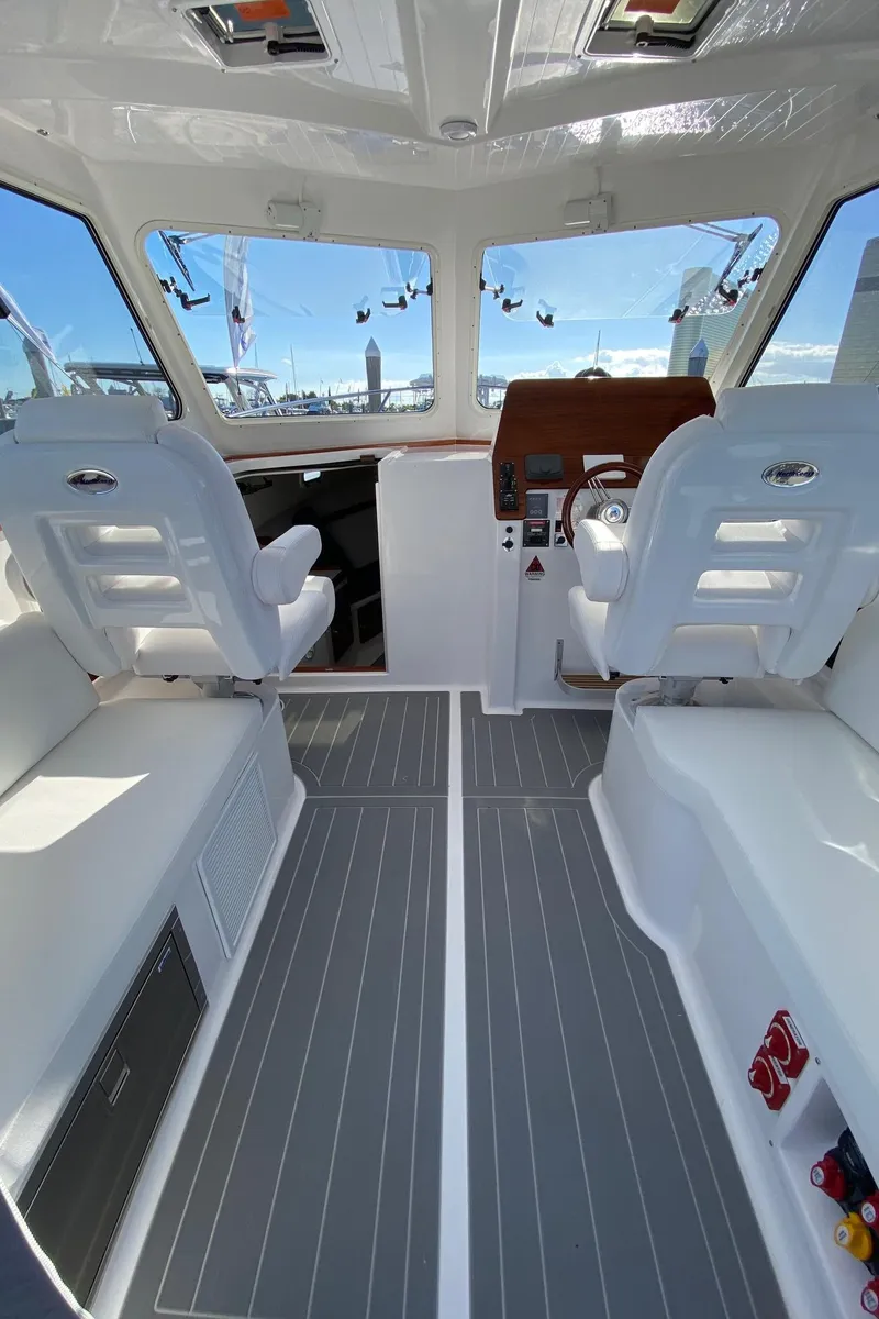 Slide: The Image of Interior of 2025 NorthCoast 315 HT boat with modern seating and controls. - 9