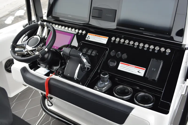 Slide: The Image of 2025 Fountain 34 CC boat dashboard with modern controls and steering wheel. - 10