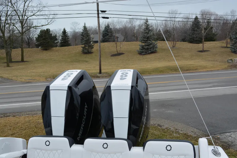 Slide: The Image of 2025 Fountain 34 CC boat with dual Mercury outboard engines, parked near a road. - 5