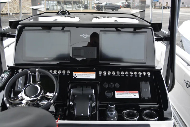 Slide: The Image of 2025 Fountain 34 CC boat dashboard with dual screens and modern controls. - 9