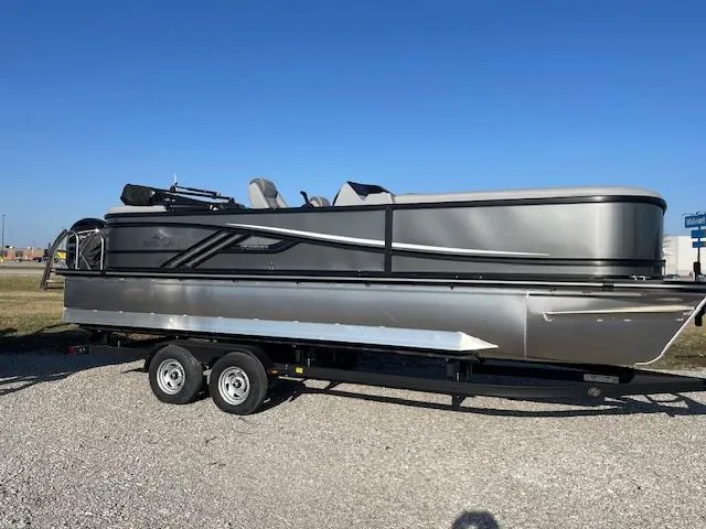 Slide: The Image of 2025 SunCatcher Fusion 324RC pontoon boat on trailer, parked on gravel. - 12