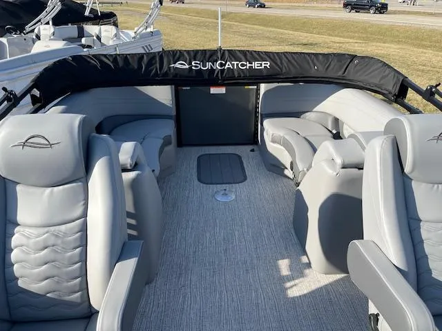 Slide: The Image of 2025 SunCatcher Fusion 324RC boat interior with gray seating and carpeted floor. - 17