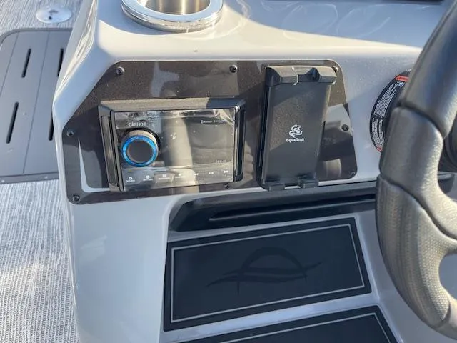 Slide: The Image of Control panel of 2025 SunCatcher Fusion 324RC boat with audio system and steering wheel. - 22