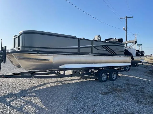 Slide: The Image of 2025 SunCatcher Fusion 324RC pontoon boat on trailer, parked on gravel. - 4