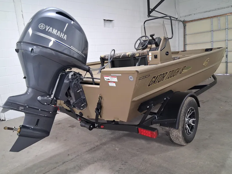 Slide: The Image of 2025 G3 Gator Tough 18 CC boat with Yamaha outboard motor in a garage. - 2