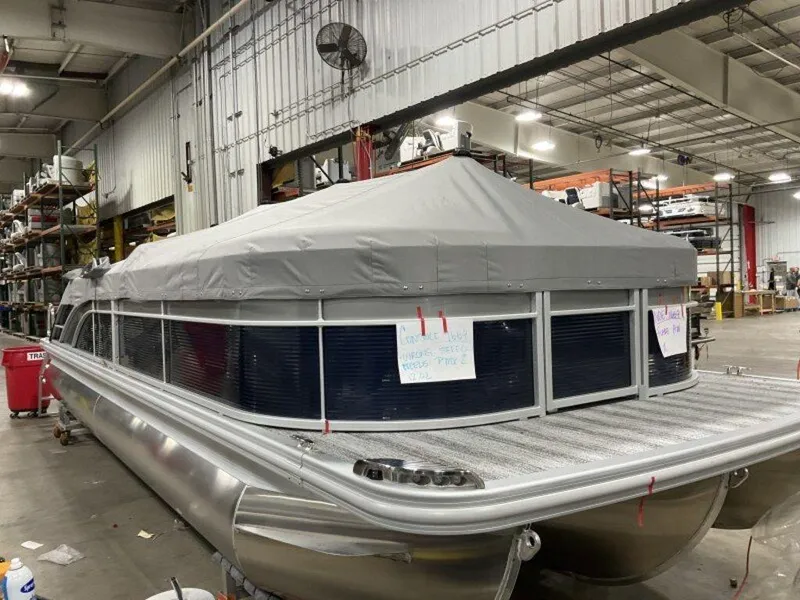 Slide: The Image of 2025 Bennington SX Swingback 25 SXSB pontoon boat in a warehouse setting. - 1