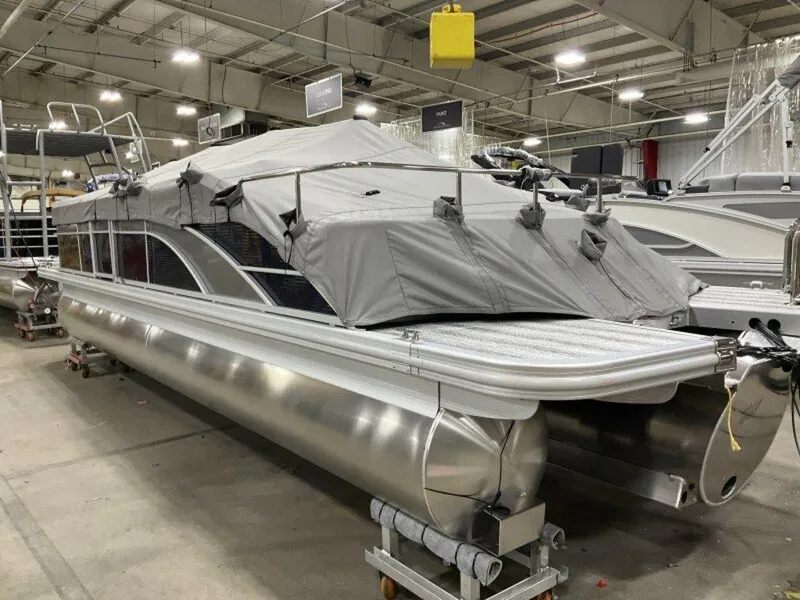 Slide: The Image of 2025 Bennington SX Swingback 25 SXSB pontoon boat with cover in indoor showroom. - 2