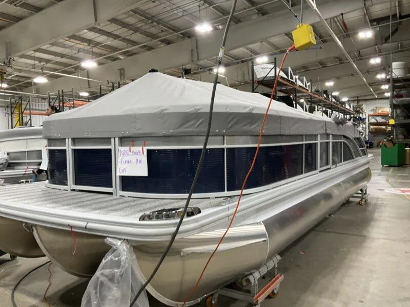 Slide: The Image of 2025 Bennington SX Swingback 25 SXSB pontoon boat in a warehouse setting. - 3