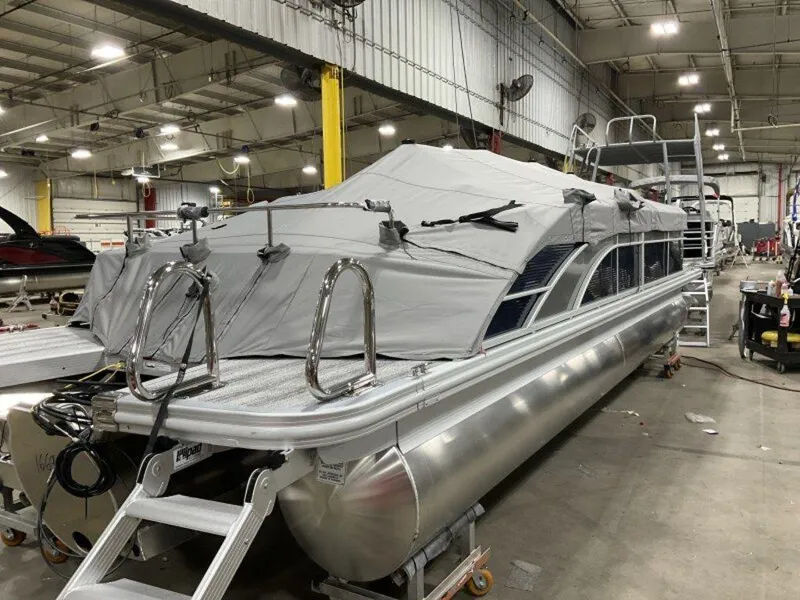 Slide: The Image of 2025 Bennington SX Swingback 25 SXSB pontoon boat in a warehouse, covered and ready for transport. - 4