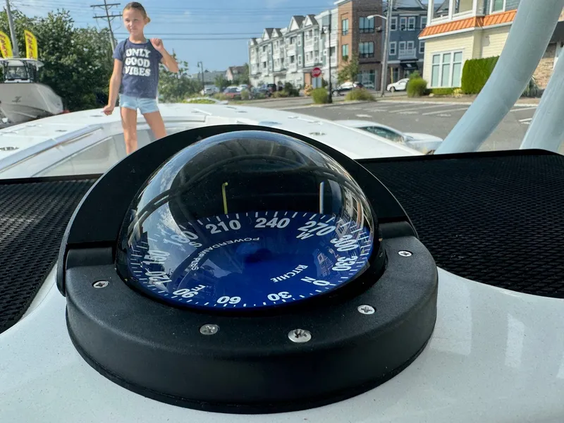 Slide: The Image of Compass on 2025 Cape Horn 32 XS boat with child in background, urban setting. - 10