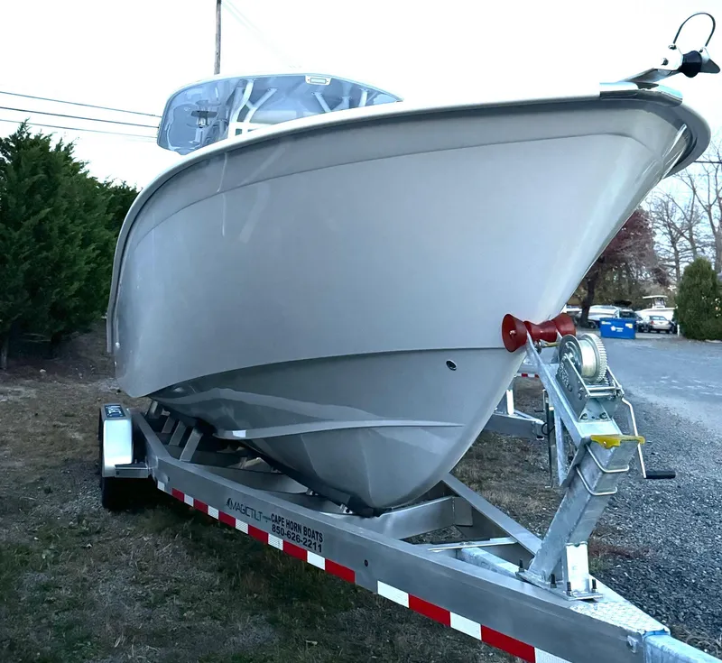 Slide: The Image of 2025 Cape Horn 32 XS boat on trailer, parked outdoors. - 2