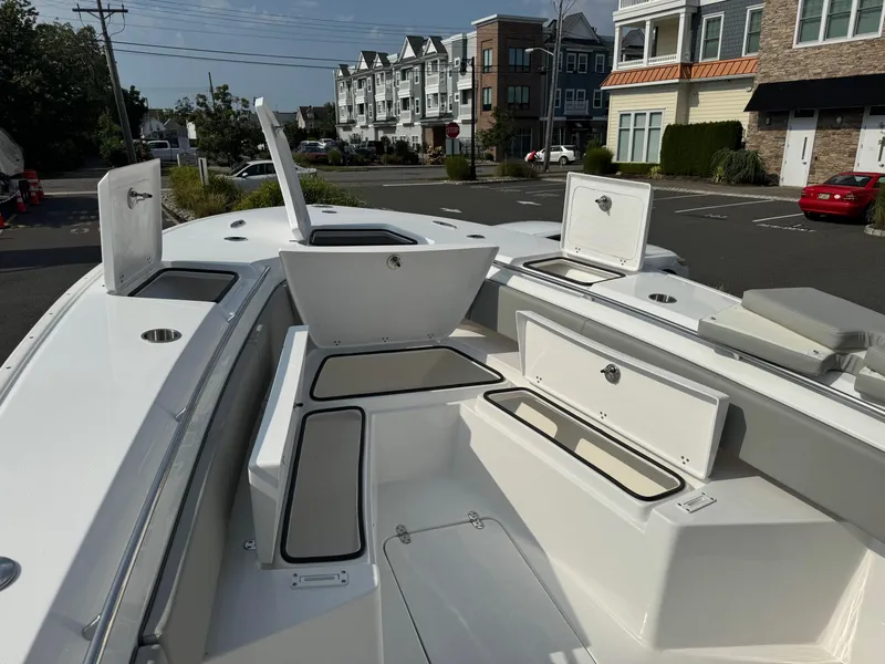 Slide: The Image of 2025 Cape Horn 32 XS boat with open storage compartments, docked in a residential area. - 5