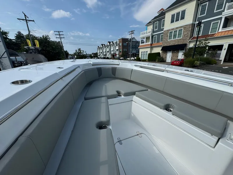 Slide: The Image of 2025 Cape Horn 32 XS boat interior with seating, docked near residential buildings. - 8
