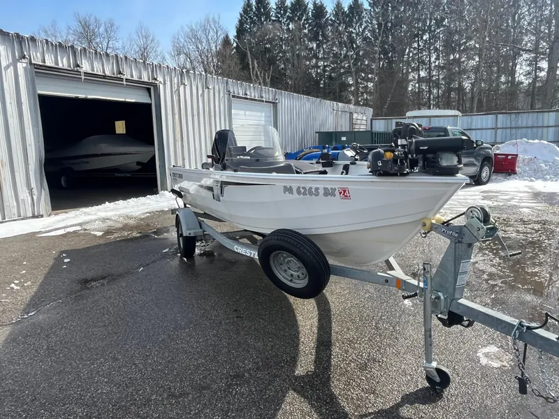 Slide: The Image of 2020 Crestliner 1800 Kodiak SC boat on trailer, parked outside a metal garage. - 11