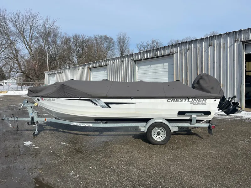 Slide: The Image of 2020 Crestliner 1800 Kodiak SC boat with cover on trailer, parked outdoors. - 9