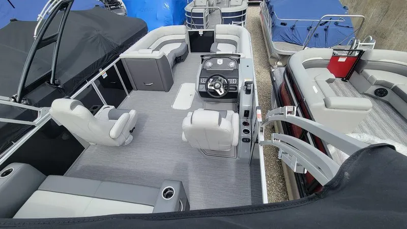 Slide: The Image of 2025 Godfrey Monaco 235 DFL boat interior with modern seating and steering console. - 10