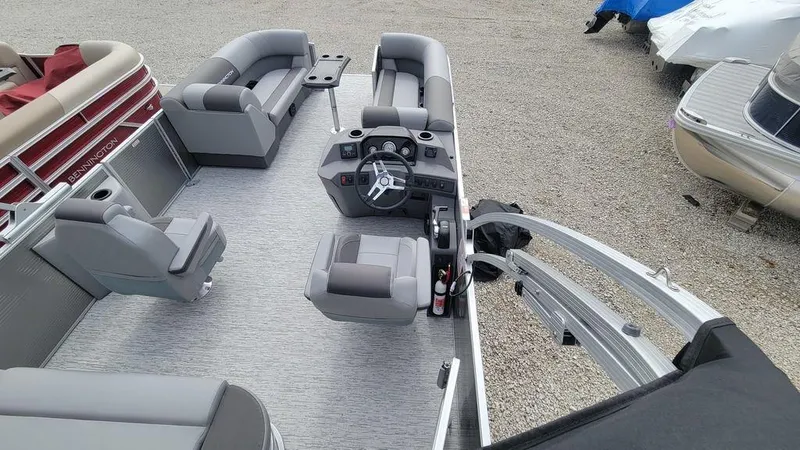 Slide: The Image of 2025 Bennington S Swingback 22 SSB pontoon boat interior with gray seating and steering console. - 20