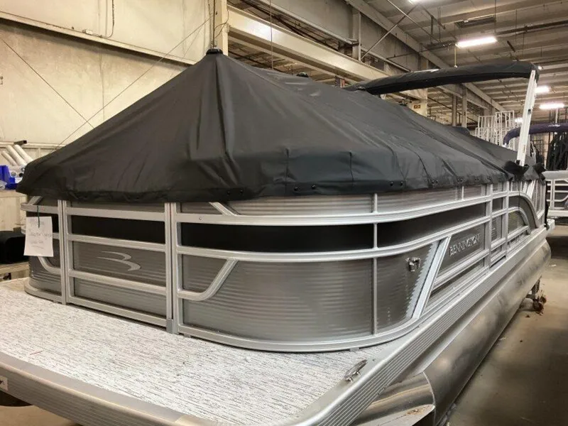 Slide: The Image of 2025 Bennington S Swingback 22 SSB pontoon boat with black cover in a warehouse. - 21