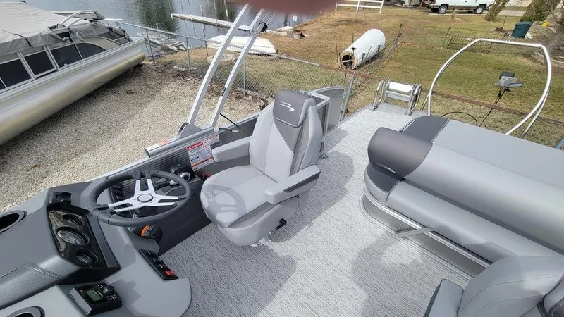 Slide: The Image of 2025 Bennington S Swingback 22 SSB pontoon boat interior with helm and seating area. - 5