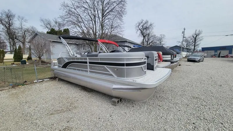 Slide: The Image of 2025 Bennington S Swingback 22 SSB pontoon boat parked on gravel lot. - 7