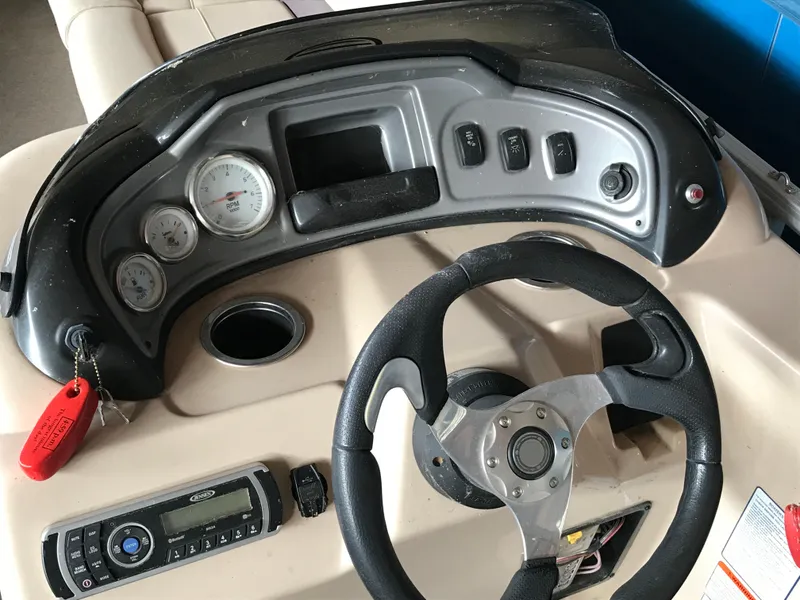 Slide: The Image of 2017 Sun Tracker Party Barge 22 DLX dashboard with steering wheel and controls. - 16