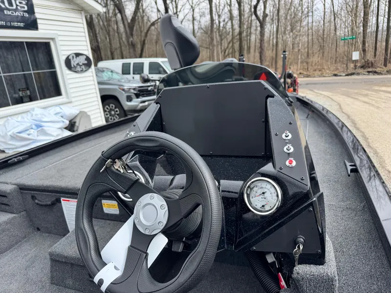 Slide: The Image of 2025 Crestliner XF189 boat dashboard with steering wheel and gauges, parked outdoors. - 5