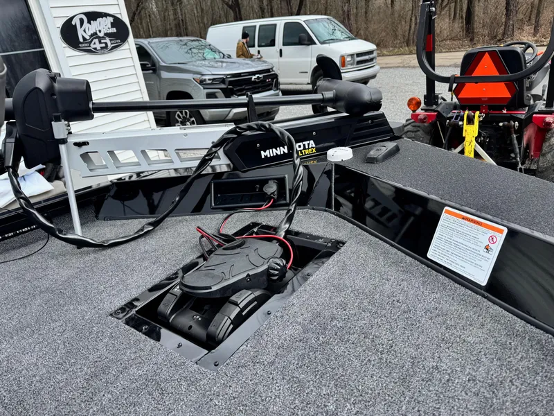 Slide: The Image of 2025 Crestliner XF189 boat with Minn Kota trolling motor, parked near vehicles and equipment. - 7