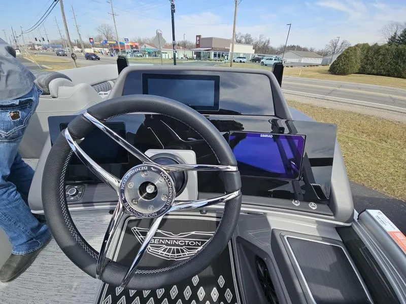 Slide: The Image of 2025 Bennington R Swingback 25 RSB boat dashboard with steering wheel and digital displays. - 15