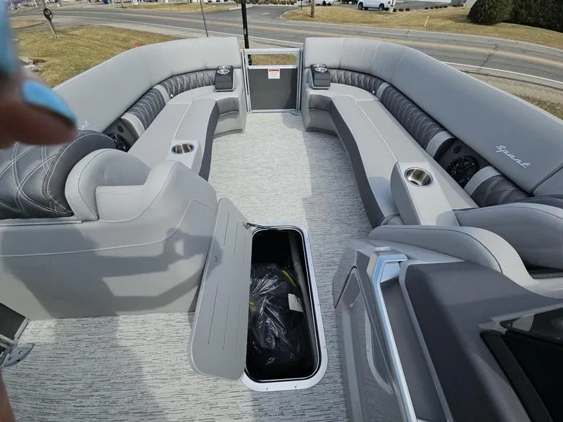 Slide: The Image of 2025 Bennington R Swingback 25 RSB pontoon boat interior with gray seating and storage compartment. - 3