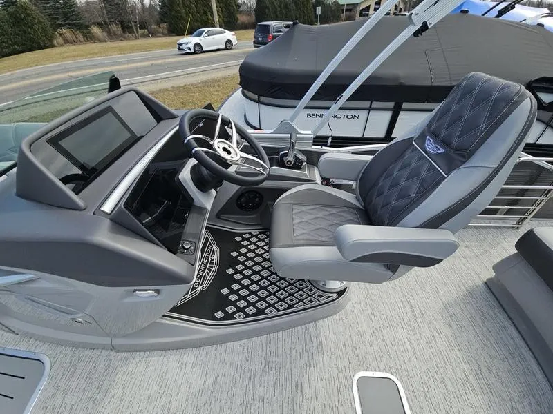 Slide: The Image of 2025 Bennington R Swingback 25 RSB boat interior with luxurious captain's chair and modern dashboard. - 6