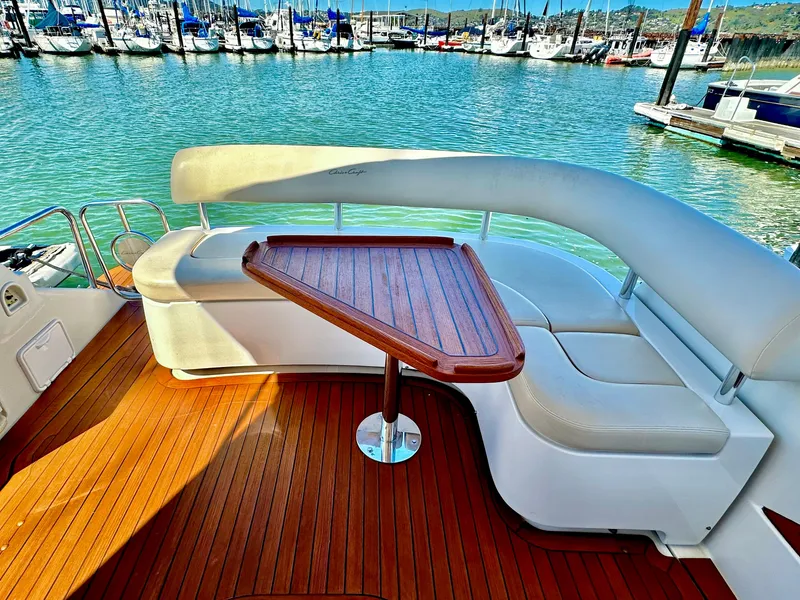 Slide: The Image of 2007 Chris-Craft Roamer 40 yacht with elegant seating and wooden table, docked at marina. - 13