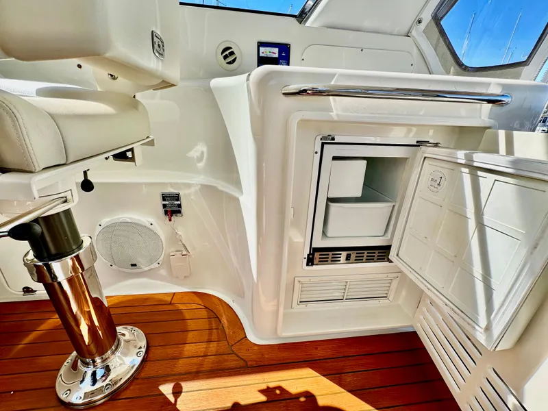 Slide: The Image of 2007 Chris-Craft Roamer 40 interior with open mini fridge and wooden flooring. - 21