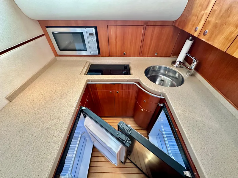 Slide: The Image of 2007 Chris-Craft Roamer 40 yacht kitchen with microwave, sink, and open fridge. - 39