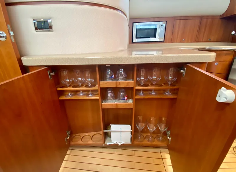 Slide: The Image of Luxurious 2007 Chris-Craft Roamer 40 yacht interior with wooden cabinetry and glassware storage. - 41