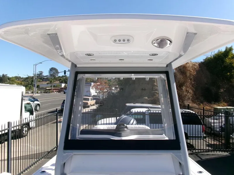 Slide: The Image of 2025 Sea Fox 248 Commander boat console with windshield and T-top in a parking lot. - 13