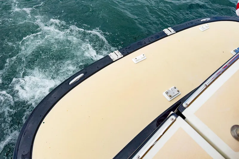 Slide: The Image of 2012 MJM 40z Downeast boat stern on water, showcasing deck and wake. - 10