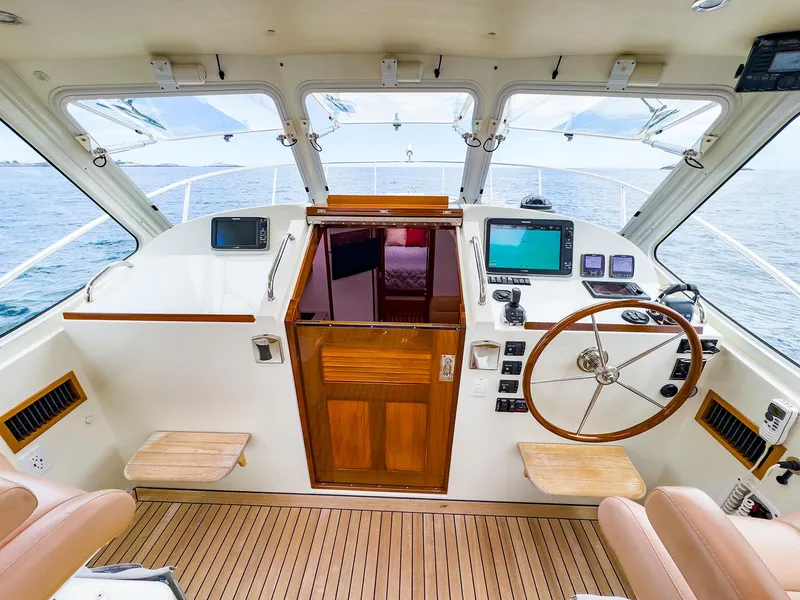 Slide: The Image of 2012 MJM 40z Downeast boat helm with wooden accents and modern navigation equipment. - 11