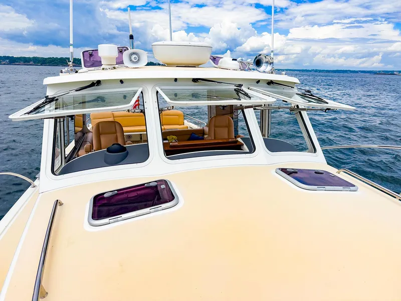 Slide: The Image of 2012 MJM 40z Downeast boat on water, featuring open windows and clear sky. - 5