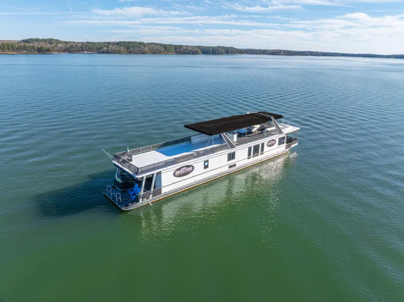 Slide: The Image of 1998 Stardust Cruisers Custom Luxury Houseboat on serene lake under clear blue sky. - 11
