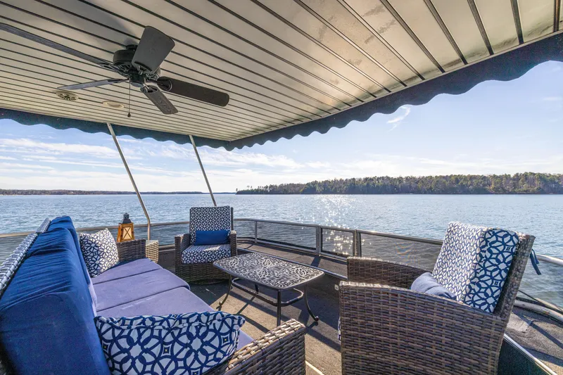 Slide: The Image of Luxurious 1998 Stardust Cruisers houseboat deck with wicker furniture and scenic lake view. - 14