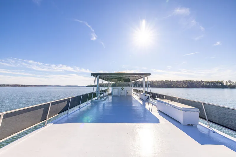 Slide: The Image of 1998 Stardust Cruisers Custom Luxury Houseboat on serene lake under clear blue sky. - 23