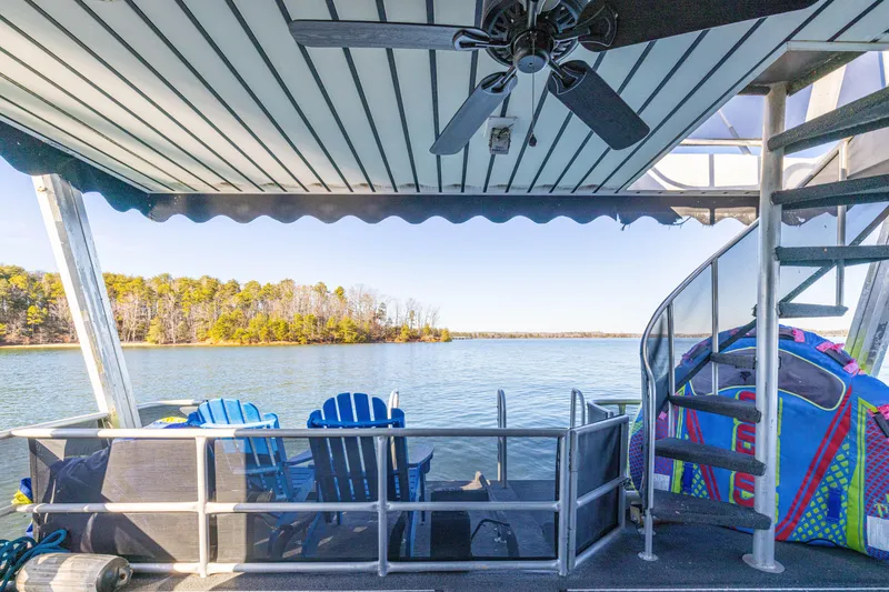 Slide: The Image of 1998 Stardust Cruisers Custom Luxury Houseboat deck with lake view, spiral staircase, and seating area. - 25